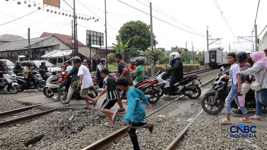 Kereta Krl melintas disamping taksi Green SM nan tertabrak KRL di perlintasan kereta Jalan Ampera, Bekasi, Selasa (28/4/2026). (CNBC Indonesia/Muhammad Sabki)