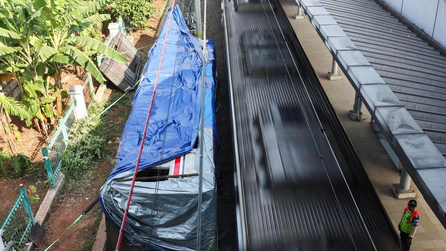 Puing-puing gerbong kereta komuter nan tertutup kain tergeletak di tanah di letak kejadian setelah tabrakan fatal antara kereta komuter dan kereta jarak jauh pada hari Senin, di Bekasi, pinggiran Jakarta, Indonesia, 29 April 2026. (REUTERS/Willy Ku