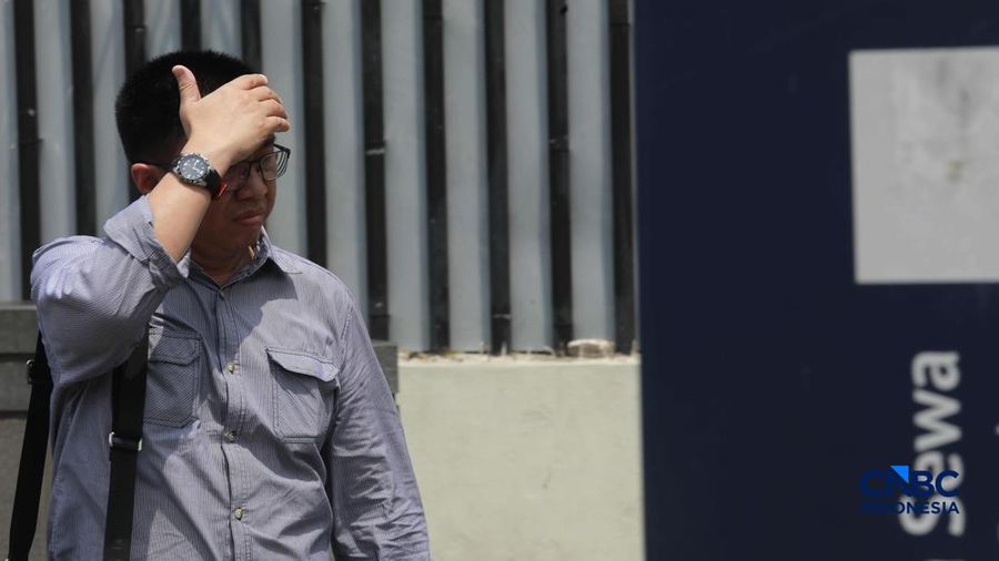 Warga melangkah dengan menutup kepala untuk berlindung dari terik mentari di Sudirman, Jakarta, Rabu (29/4/2026).
