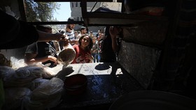 Displaced Palestinians queue to receive a food portion from a charity kitchen in the Bureij refugee camp, in the central Gaza Strip on May 1, 2026. The war on the Gaza Strip was sparked following the militant Palestinian group Hamas's October 7, 2023