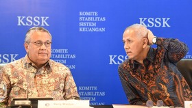 Gubernur Bank Indonesia (BI) Perry Warjiyo (kiri) berbincang dengan Ketua Dewan Komisioner LPS Anggito Abimanyu (kanan) saat konferensi pers penyampaian hasil Rapat Komite Stabilitas Sistem Keuangan (KSSK) kuartal I 2026 di Jakarta, Kamis (7/5/2026).