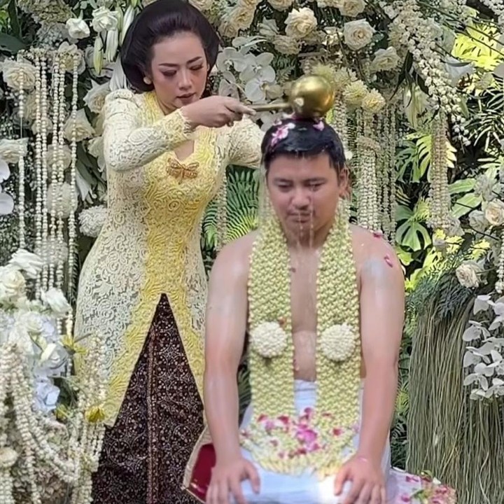 <p>Soimah pun turut memberikan siraman kepada Aksa dengan penuh kasih sayang. Di momen yang spesial itu, Soimah tampak anggun mengenakan kebaya adat Jawa tradisional berwarna <em>butter yellow</em> yang membuat penampilannya terlihat semakin elegan. (Foto: Instagram @mamuktukangmakeupjogja /@showimah)</p>