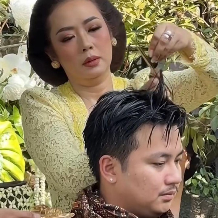 <p>Setelah prosesi penyucian diri selesai dilakukan, rangkaian acara dilanjutkan dengan pemotongan rambut atau yang dikenal sebagai potong rikmo. Pada momen tersebut, Soimah tampak memotong rambut Aksa sebagai simbol membersihkan diri serta membuang hal-hal buruk sebelum memasuki kehidupan baru. (Foto: Instagram @mamuktukangmakeupjogja /@showimah)</p>