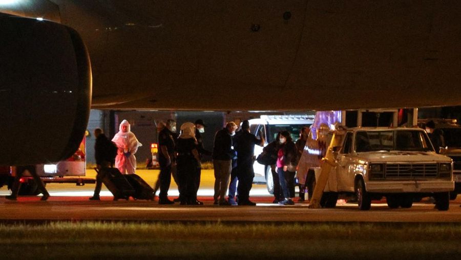 Seorang petugas dengan busana pelindung biohazard membantu proses penurunan penumpang nan dievakuasi dari kapal pesiar MV Hondius, nan terkena pandemi hantavirus, dan tiba dengan pesawat sewaan di Bandara Eppley di Omaha, Nebraska, AS, Senin (11/5/2