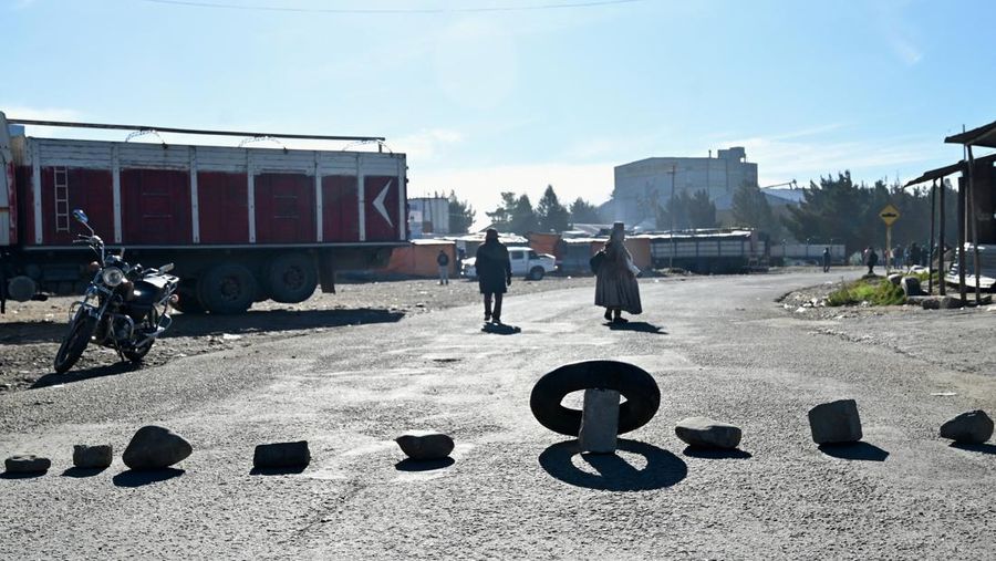 Seorang wanita melangkah melewati batu-batu nan menghalangi salah satu pintu masuk kota sembari menuntut pengunduran diri Presiden Rodrigo Paz di tengah krisis ekonomi dan bahan bakar nan sedang berlangsung, di El Alto, Bolivia, 11 Mei 2026.
