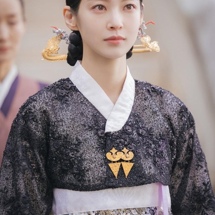 <p>Tak hanya hanbok berwarna keemasan,&nbsp;Gong Seung Yeon juga tampil dengan hanbok berwarna gelap. Warna yang kontras dengan kulit putihnya dan hiasan emas di kepalanya ini meninggalkan kesan yang sangat elegan. (Foto: Instagram varoent_official)</p>