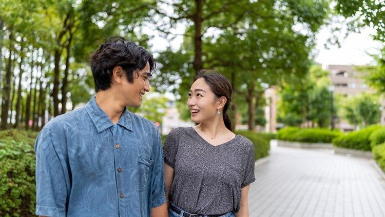 Japanese married couple standing outside&comma; looking eye to eye