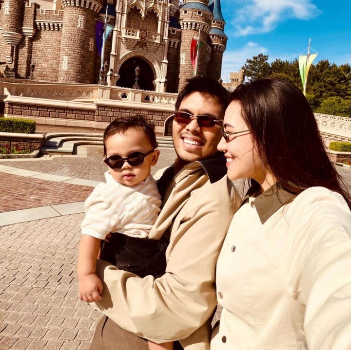 <p>Dalam unggahan lainnya, <em>Baby</em> Arash terlihat begitu menggemaskan saat mengenakan kacamata hitam. Dengan latar pemandangan kastel di Tokyo Disneyland, keluarga kecil ini tampak begitu <em>stylish</em>. (Foto: Instagram @aaliyah.massaid / @thariqhalilintar)</p>