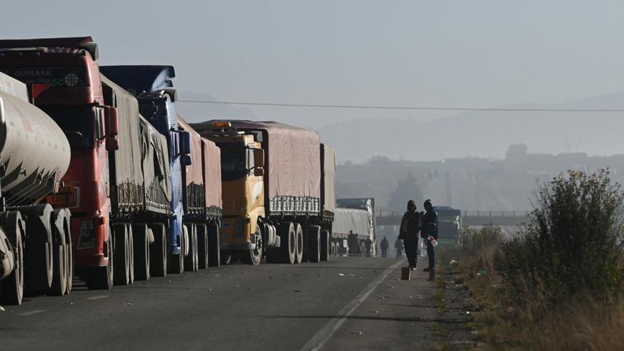 Para pengemudi pikulan beristirahat di samping truk mereka setelah terdampar selama berhari-hari lantaran para pengunjuk rasa memblokir jalan raya utama menuntut pengunduran diri Presiden Rodrigo Paz di tengah krisis ekonomi dan bahan bakar nan sedang berlangsung, di Apacheta, Bolivia, 13 Mei 2026.