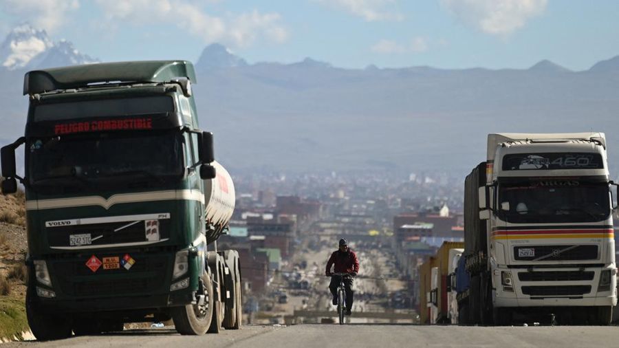 Seseorang mengendarai sepeda melewati truk-truk nan terhenti selama berhari-hari lantaran para pengunjuk rasa memblokir jalan raya utama menuntut pengunduran diri Presiden Rodrigo Paz di tengah krisis ekonomi dan bahan bakar nan sedang berlangsung, di Apacheta, Bolivia, 13 Mei 2026.