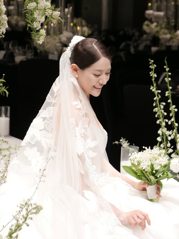 Inilah potret lebih dekat kebahagahiaan Park Eun Young sebagai mempelai perempuan, Beauties. Paras anggunnya sungguh menawan dengan tatanan rambut low bun dan berlapiskan veil berornamen bunga./ Foto: instagram.com/allforyou_snap