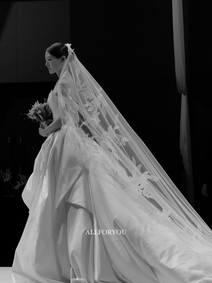 Ketika menaiki altar pernikahan, Beauties dapat menyaksikan keindahan penampilan Park Eun Young dalam balutan gaun pengantin bepotongan cantik yang memadukan kain satin dan kain tulle pada bagian veil panjangnya./ Foto: instagram.com/allforyou_snap
