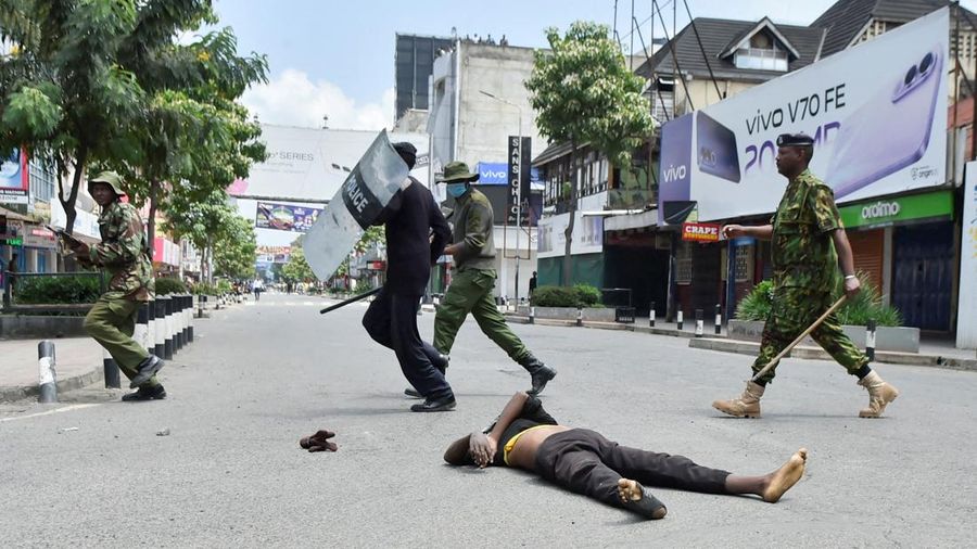 Petugas polisi anti huru hara berlari untuk membubarkan demonstran melewati mayit seorang laki-laki nan tewas selama pemogokan operator transportasi umum nan dipicu oleh kenaikan biaya bahan bakar mengenai dengan tekanan pasokan global, di kota Nakuru, Lembah Rift, Kenya, 18 Mei 2026. (REUTERS/Suleiman Mbatiah)
