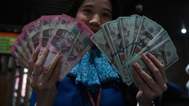 Karyawan menunjukkan uang pecahan rupiah dan dolar Amerika Serikat (AS) di gerai penukaran mata uang asing Haji La Tunrung, Makassar, Sulawesi Selatan, Rabu (20/5/2026). Bank Indonesia (BI) segera membatasi pembelian mata uang dolar AS tanpa dokumen 