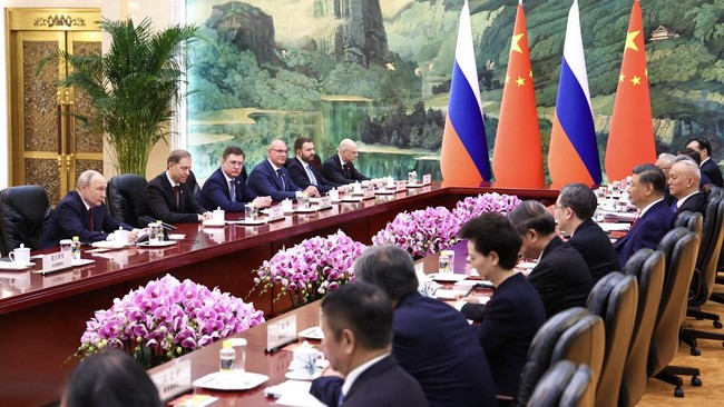 In this pool photograph distributed by the Russian state agency Sputnik, Russia's President Vladimir Putin (L) and China's President Xi Jinping (2nd R) take part in a meeting in Beijing on May 20, 2026. (Photo by Alexander KAZAKOV / POOL / AFP)