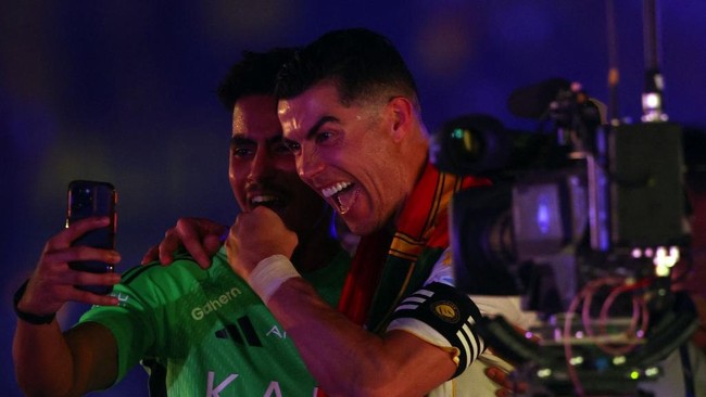 Nassr's Portuguese forward #07 Cristiano Ronaldo (R) takes a selfie as he celebrates after winning the Saudi Pro League title at the end of their football match against Damac at the Al-Awwal Park Stadium in Riyadh on May 21, 2026. (Photo by Fayez NUR