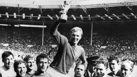 England's national soccer team captain Bobby Moore holds aloft the Jules Rimet trophy as he is carried by his teammates following England's victory over Germany (4-2 in extra time) in the World Cup final 30 July 1966 at Wembley stadium in London.(Fro