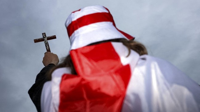 A protester holds a crucifix while takes part in a