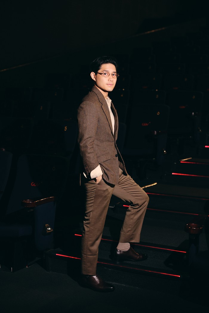 Teuku Rassya yang memerankan karakter Erza tampil rapi dalam setelan jas coklat serta kemeja beige. / Foto: Dok. iQIYI