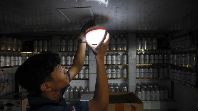 Pedagang menggunakan penerangan darurat saat terjadi pemadaman listrik di Banda Aceh, Aceh, Sabtu (23/5/2026).
