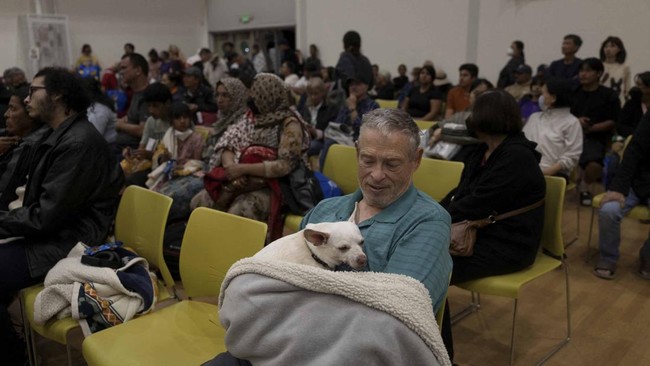 Dennis Christian and his dog Rue rest at a temporary shelter in Fountain Valley, California, following their evacuation prompted by a failing chemical tank containing methyl methacrylate, a flammable liquid used in the aerospace industry, in nearby G
