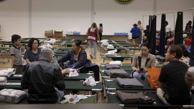 Residents sit at a temporary shelter in Fountain Valley, California, following evacuations prompted by a failing chemical tank containing methyl methacrylate, a flammable liquid used in the aerospace industry, in nearby Garden Grove, California, U.S.