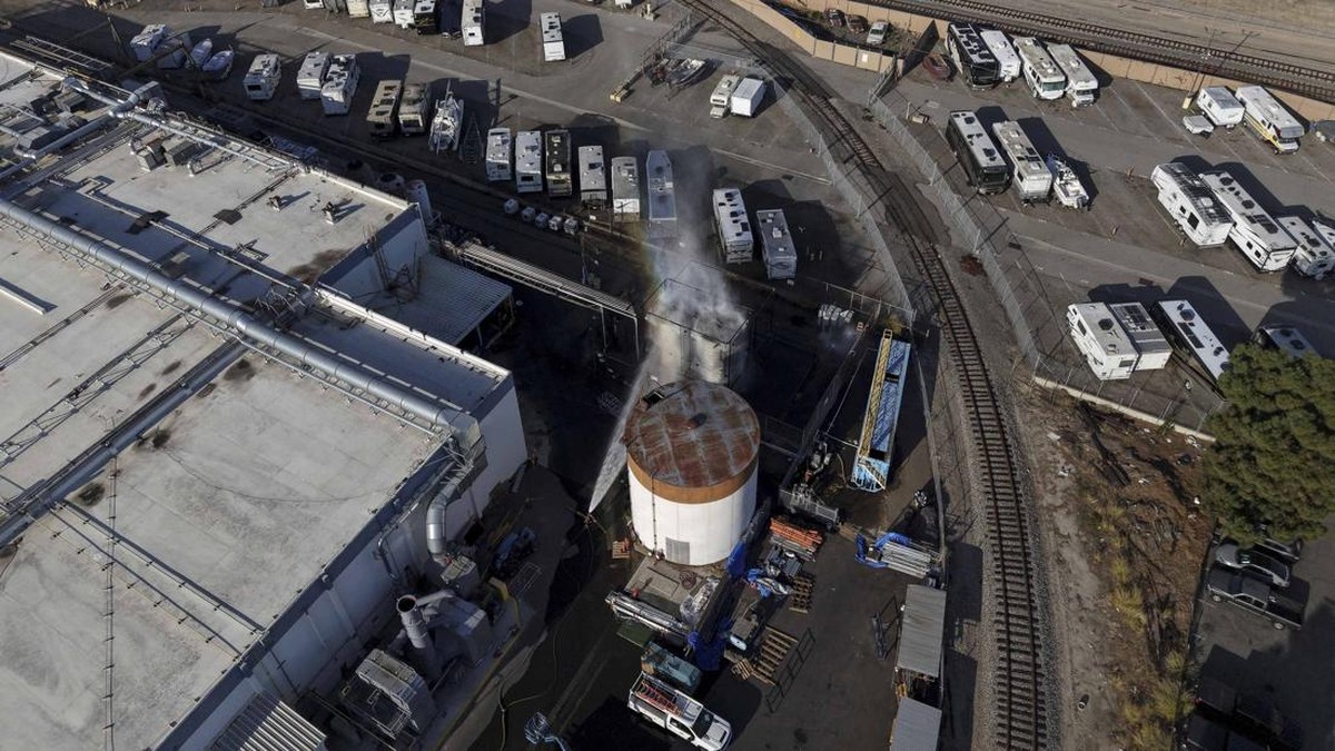 A drone picture shows water being sprayed on a tank as a chemical incident involving a failing tank of flammable liquid called methyl methacrylate, used in the aerospace industry, has forced an evacuation in the surrounding area in Garden Grove, Cali
