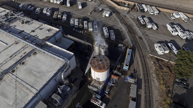 A drone picture shows water being sprayed on a tank as a chemical incident involving a failing tank of flammable liquid called methyl methacrylate, used in the aerospace industry, has forced an evacuation in the surrounding area in Garden Grove, Cali