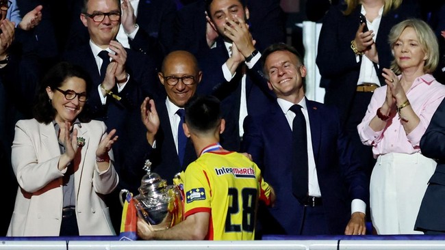 Soccer Football - Coupe de France - Final - RC Lens v OGC Nice - Stade de France, Saint Denis, France - May 22, 2026 RC Lens' Adrien Thomasson collects the trophy from French President Emmanuel Macron after winning the Coupe de France REUTERS/Stephan