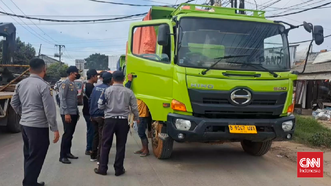 Petugas mendampingi warga yang mengadang truk tambang beroperasi di luar jam operasional yang sudah disepakati di Legok, Tangerang. 