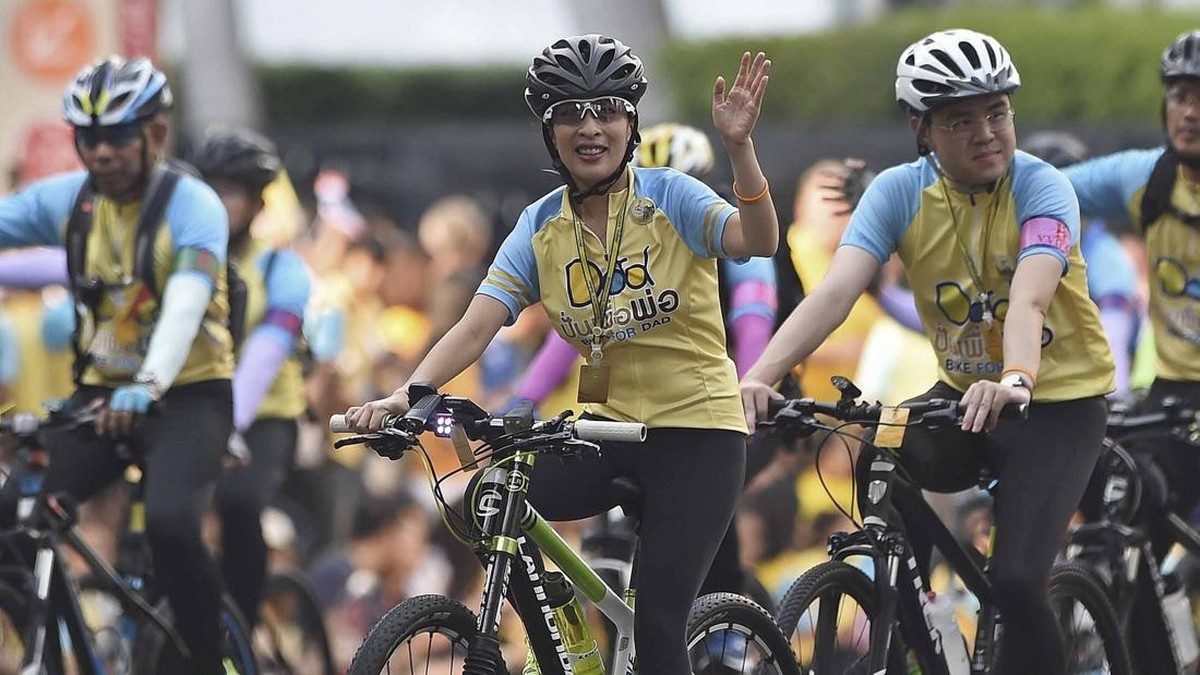 Thailand's Princess Bajrakitiyabha (C) waves as she rides a bicycle during a mass cycle event to honour King Bhumibol Adulyadej in Bangkok on December 11, 2015.  Thailand's crown prince Maha Vajiralongkorn led the symbolic 'Bike for Dad' event as par