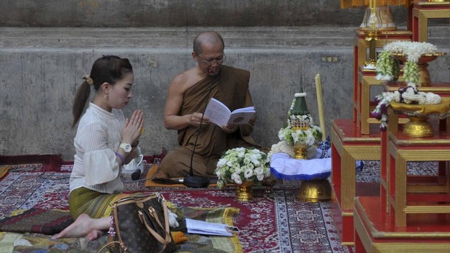 In this photograph taken on June 17, 2015, Princess Bajrakitiyabha of Thailand (L) offers prayers at The Mahabodhi Temple in Bodhgaya.  The Buddhist Temple in the northern state of Bihar is a UNESCO World Heritage Site, and marks the location where S