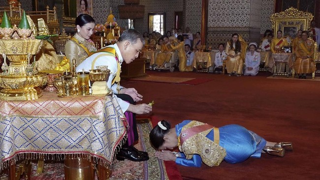 This handout from the Thai Royal Household Bureau taken and released on May 5, 2019 shows Thailand's King Maha Vajiralongkorn (C) annointing his daughter Princess Bajrakitiyabha Manidol (R), as Queen Suthida watches, during a coronation ceremony in t