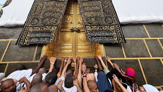 Muslim pilgrims reach out to touch the Kaaba's door at the Grand Mosque, ahead of the annual hajj pilgrimage, in the holy city of Mecca, Saudi Arabia, May 22, 2026. Picture taken with a mobile phone. REUTERS/Ibraheem Abu Mustafa     TPX IMAGES OF THE
