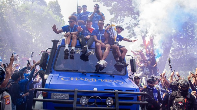 Tim dan ofisial Persib Bandung yang naik di atas bus terbuka menyapa warga saat konvoi juara Super League 2025–2026 di Bandung, Jawa Barat, Minggu (24/5) pagi. (ANTARA FOTO/Novrian Arbi)