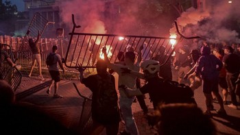 A group of demonstrators clash with riot police outside Serbia's parliament building during clashes that erupt at the end of an anti-government protest decrying corruption and calling for early elections following the collapse of a railway station ca