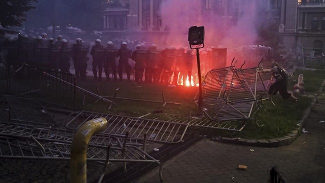 A group of demonstrators clash with riot police outside Serbia's parliament building during clashes that erupt at the end of an anti-government protest decrying corruption and calling for early elections following the collapse of a railway station ca