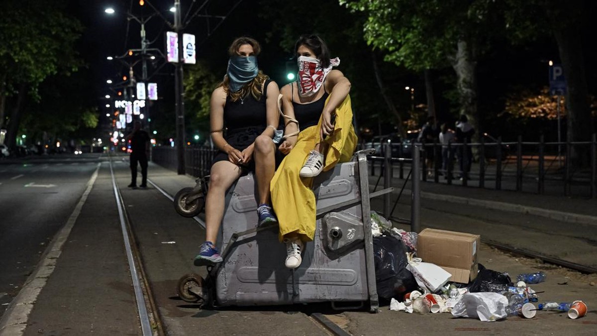 Demonstrators sit on a container on a street as clashes erupted at the end of an anti-government protest decrying corruption and calling for early elections following the collapse of a railway station canopy in Novi Sad that killed 16 in November 202