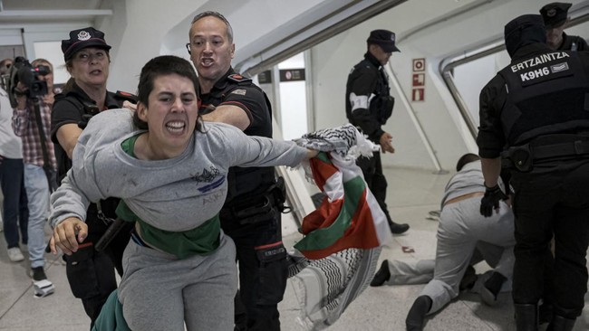 Basque police officers detain members of the Global Sumud Flotilla upon their arrival at Bilbao airport on May 23, 2026. Police detained four people at Bilbao airport in northern Spain on May 23, 2026 following clashes that broke out after activists