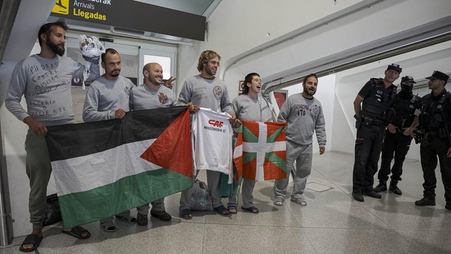 Basque police officers detain members of the Global Sumud Flotilla upon their arrival at Bilbao airport on May 23, 2026. Police detained four people at Bilbao airport in northern Spain on May 23, 2026 following clashes that broke out after activists