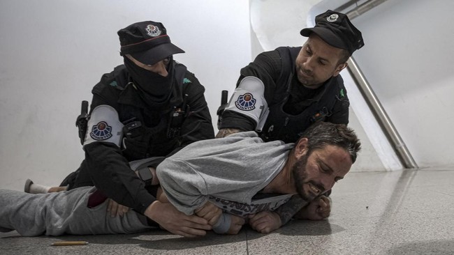 Basque police officers detain members of the Global Sumud Flotilla upon their arrival at Bilbao airport on May 23, 2026. Police detained four people at Bilbao airport in northern Spain on May 23, 2026 following clashes that broke out after activists