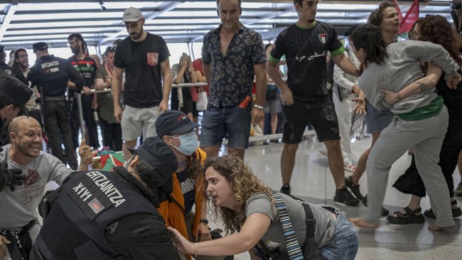 Basque police officers detain members of the Global Sumud Flotilla upon their arrival at Bilbao airport on May 23, 2026. Police detained four people at Bilbao airport in northern Spain on May 23, 2026 following clashes that broke out after activists