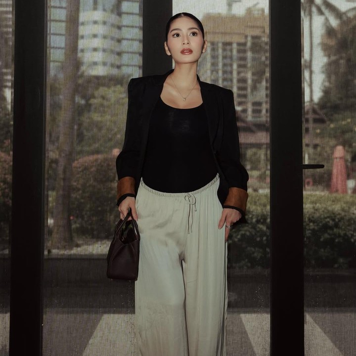 <p>Dalam satu foto, Debi memamerkan gaya modisnya saat padu padan atasan <em>tanktop</em> hitam dengan celana kulot kain berwarna <em>ivory</em>. Perempuan 29 tahun ini menyempurnakan gayanya dengan tas hitam kecil berbentuk kotak dan <em>blazer</em> hitam. Meski terlihat simpel, gaya pakaian Debi ini tampak elegan. (Foto: Instagram @debisagita)</p>