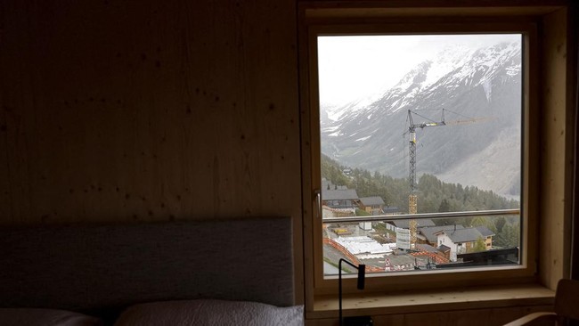 A construction site is seen trough a guest room window of the newly built Momentum Lodge at the Lauchernalp in Wiler, nearly a year after a massive rock and ice slide triggered by the collapse of the Birch Glacier destroyed much of the village of Bla