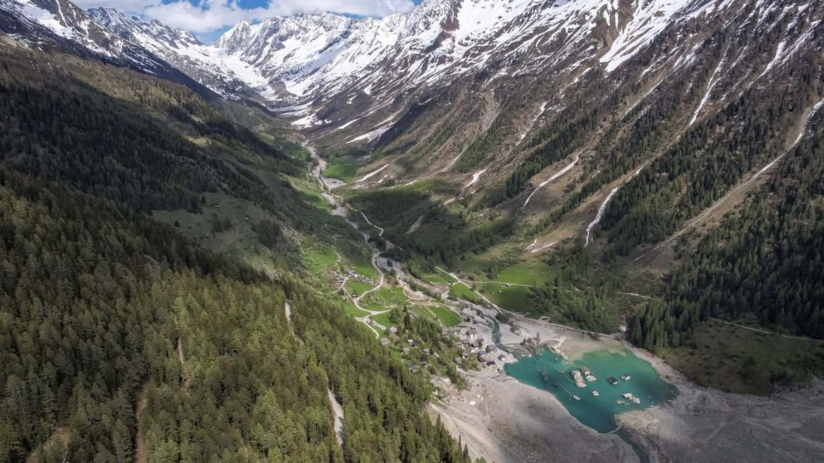 A drone view shows a few remaining houses surrounded by the Lonza River nearly a year after a massive rock and ice slide triggered by the collapse of the Birch Glacier destroyed much of the village of Blatten, Switzerland, May 13, 2026. REUTERS/Denis