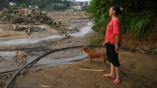A resident stands near debris in Daqiao village following flash floods and landslides triggered by extreme rainfall, in Yongchuan district, Chongqing, China May 24, 2026. cnsphoto via REUTERS ATTENTION EDITORS - THIS IMAGE WAS PROVIDED BY A THIRD PAR