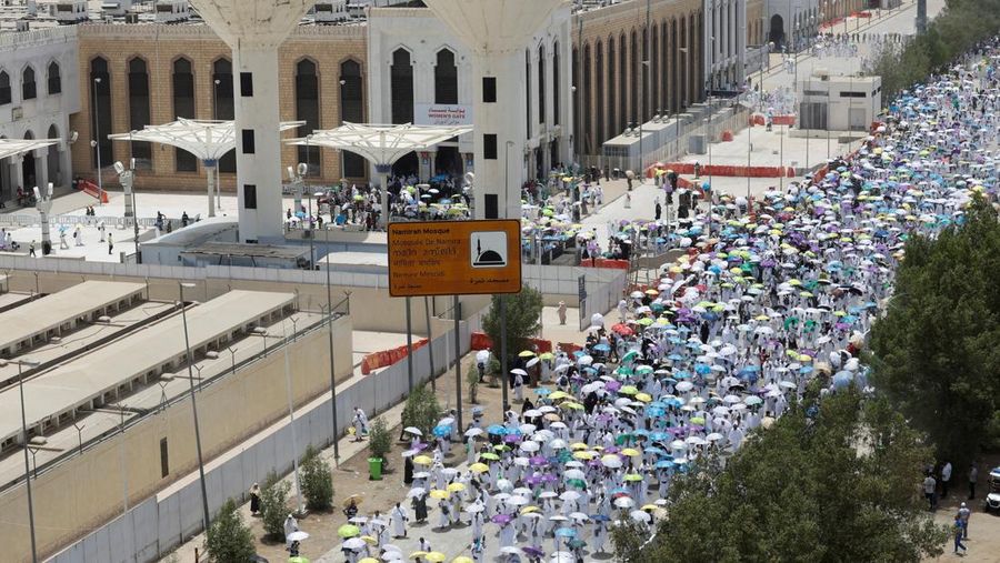 Para peziarah Muslim menggunakan payung untuk melindungi diri dari terik mentari pada hari salat Zuhur di luar Masjid Nimrah di Dataran Arafat selama ibadah haji tahunan, di luar kota suci Mekah, Arab Saudi, 26 Mei 2026.