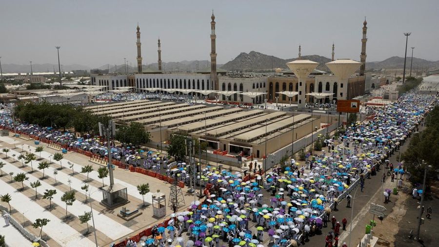 Para peziarah Muslim menggunakan payung untuk melindungi diri dari terik mentari setelah salat Zuhur di luar Masjid Nimrah di Dataran Arafat selama ibadah haji tahunan, di luar kota suci Mekah, Arab Saudi, 26 Mei 2026. (REUTERS/Ibraheem Abu Mustafa)