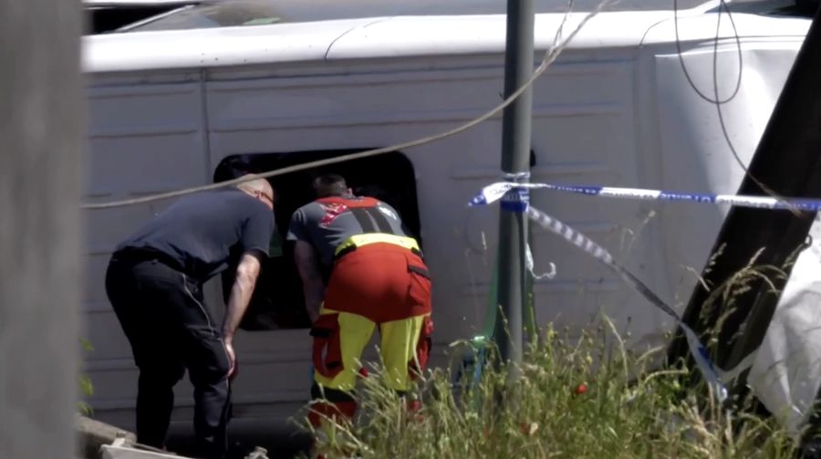 Tim penyelamat memandang bus sekolah nan rusak usai tertabrak kereta di sebuah perlintasan rel di wilayah Flanders utara, Beglia Selasa (26/5/2026) pagi waktu setempat.