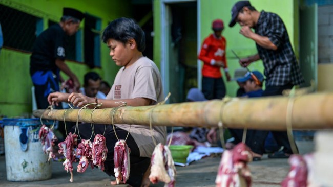 Petugas penyembelihan hewan kurban menalikan daging hewan kurban menggunakan tali bambu di Kampung Salakaso, Desa Mandalahaji, Kecamatan Pacet, Kabupaten Bandung, Jawa Barat, Rabu (27/5/2026). Panitia penyembelihan hewan kurban di Kampung Salakaso me